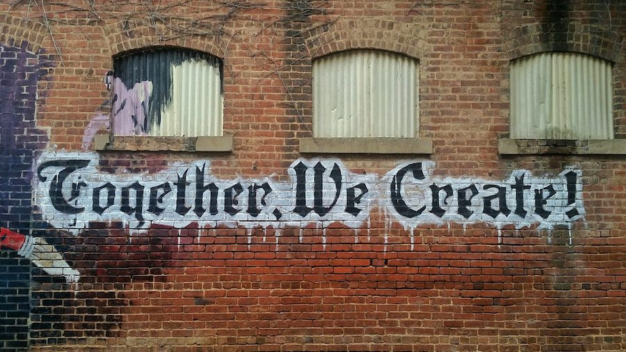 brick wall with words Together We Create